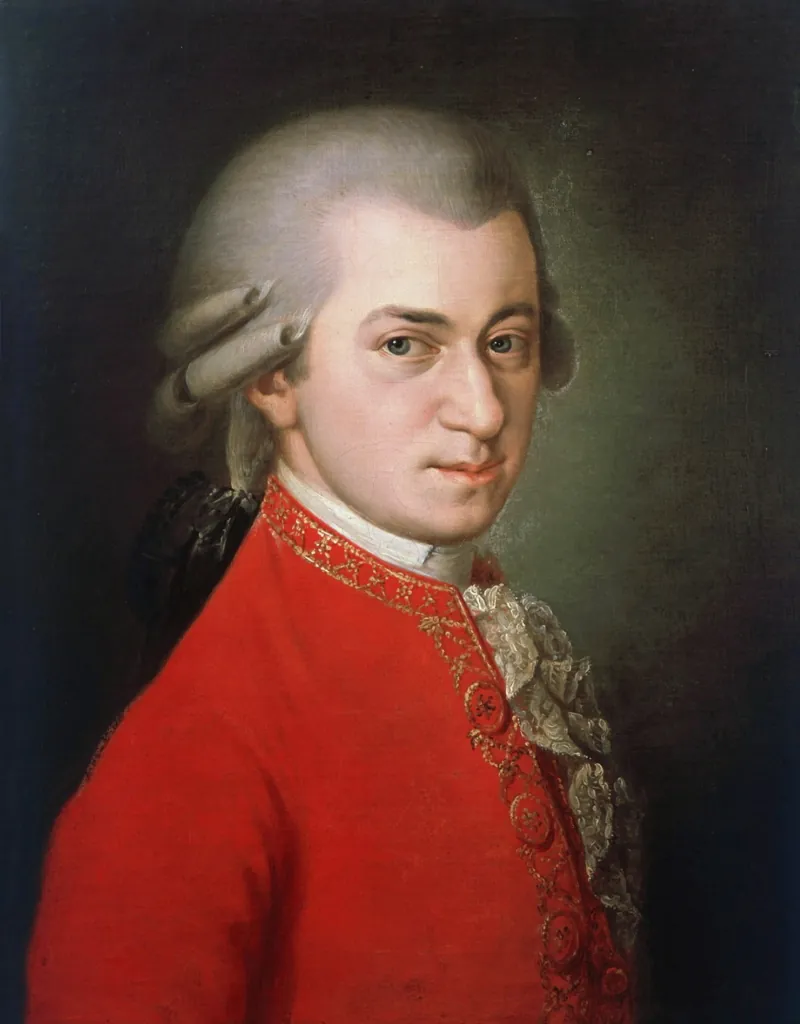 Ein Porträt von Wolfgang Amadeus Mozart in rotem Rock mit einem Notenblatt in der Hand